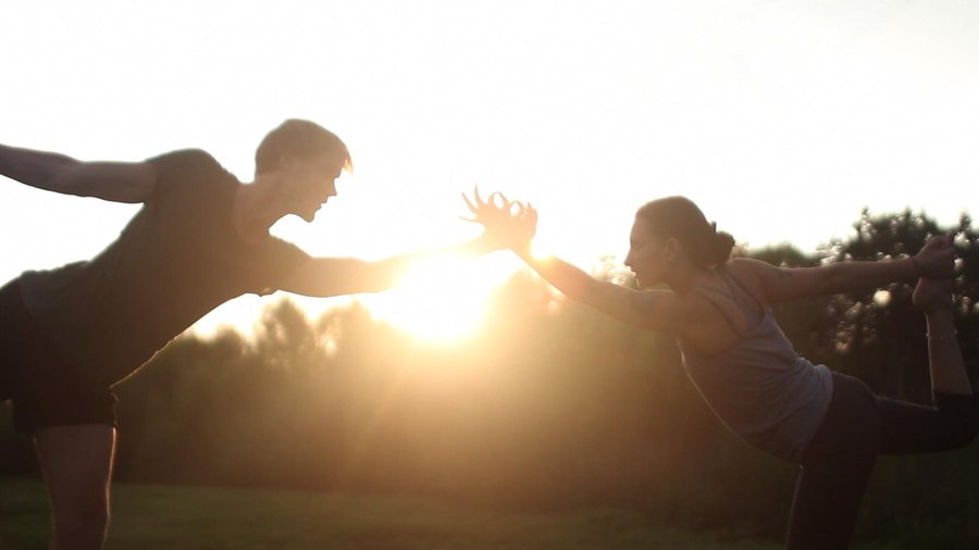 Two yoga practitioners in dancer's pose at sunset, from The Kingdom Within